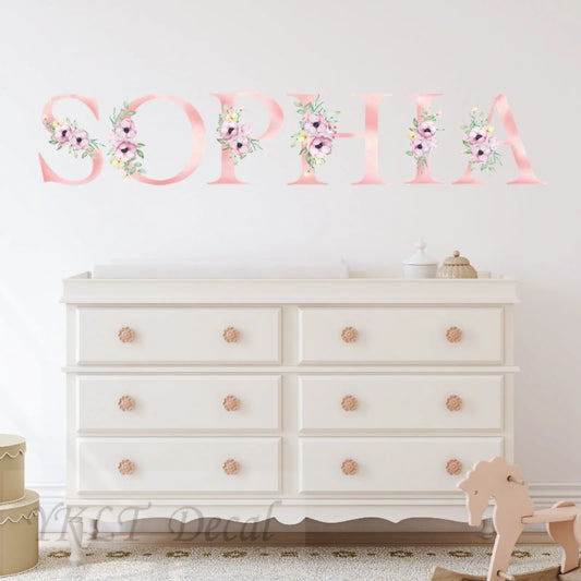 Personalized floral name wall decal above nursery dresser, custom kids room decor by YKLT Decals