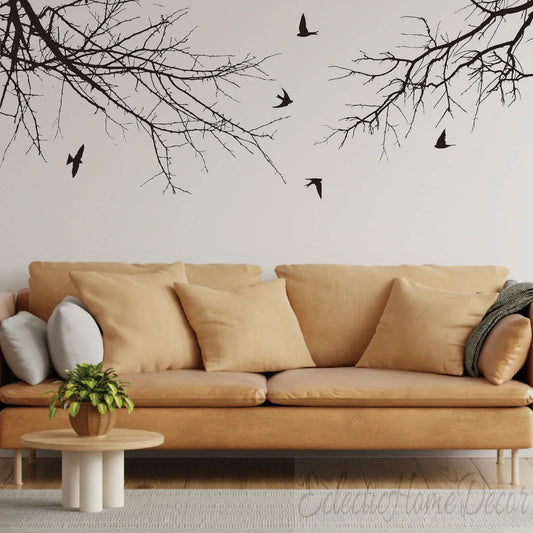Modern living room with tan sofa and YKLT Decals wall art featuring tree branches and birds.