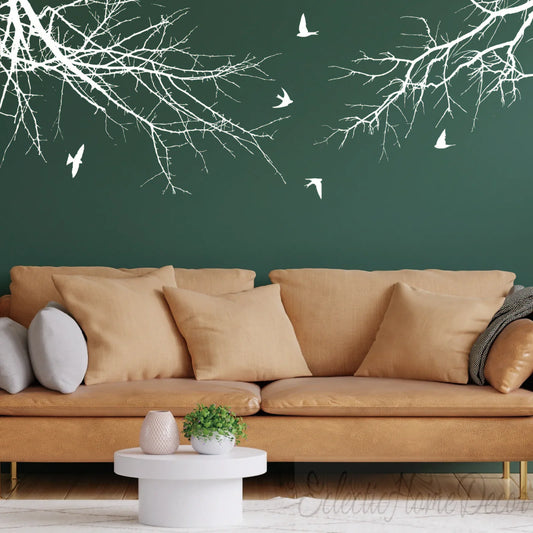 Modern living room with tan sofa, green wall, and YKLT Decals white tree branch and bird wall decals
