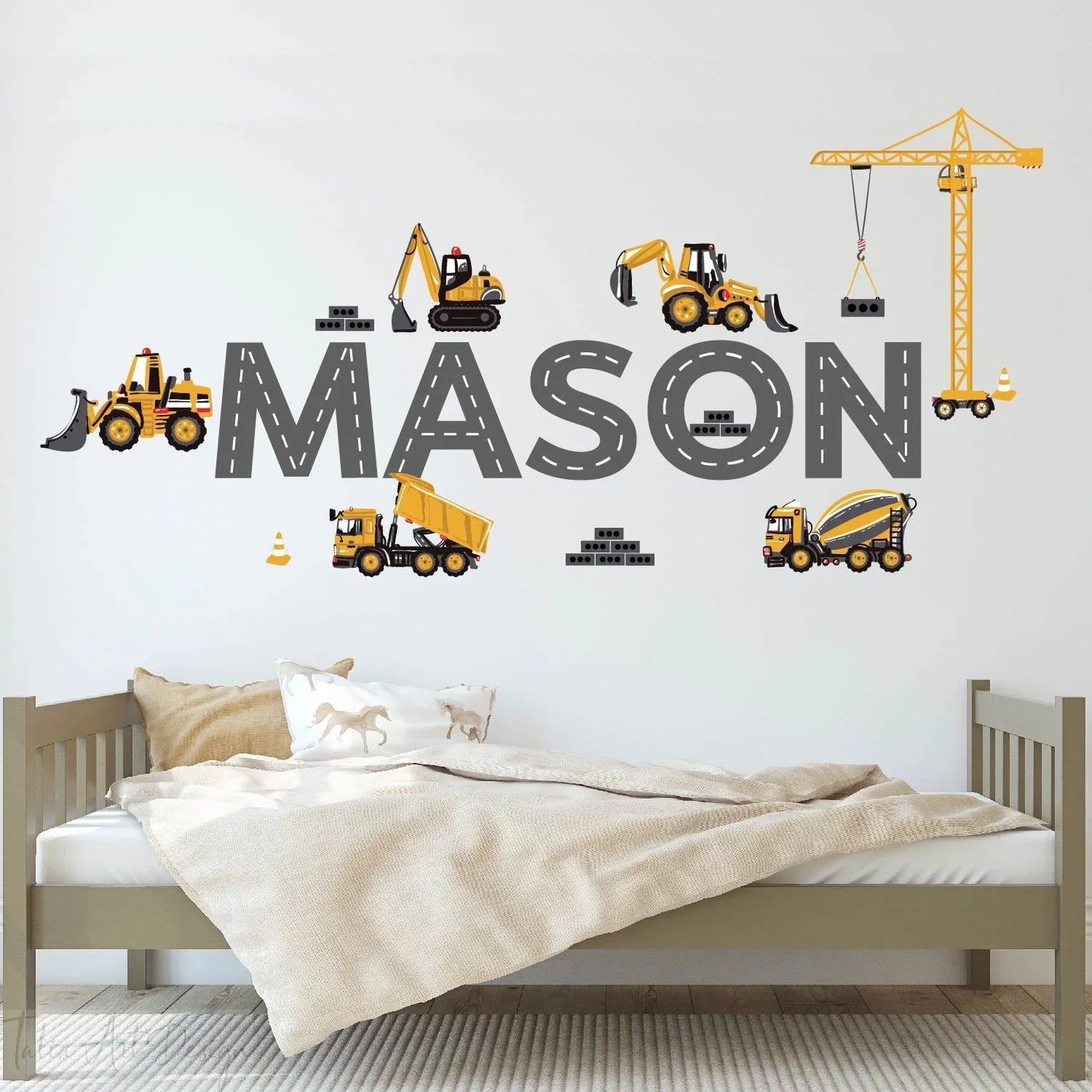 Personalized kids room wall decal with construction vehicles and the name Mason above a bed
