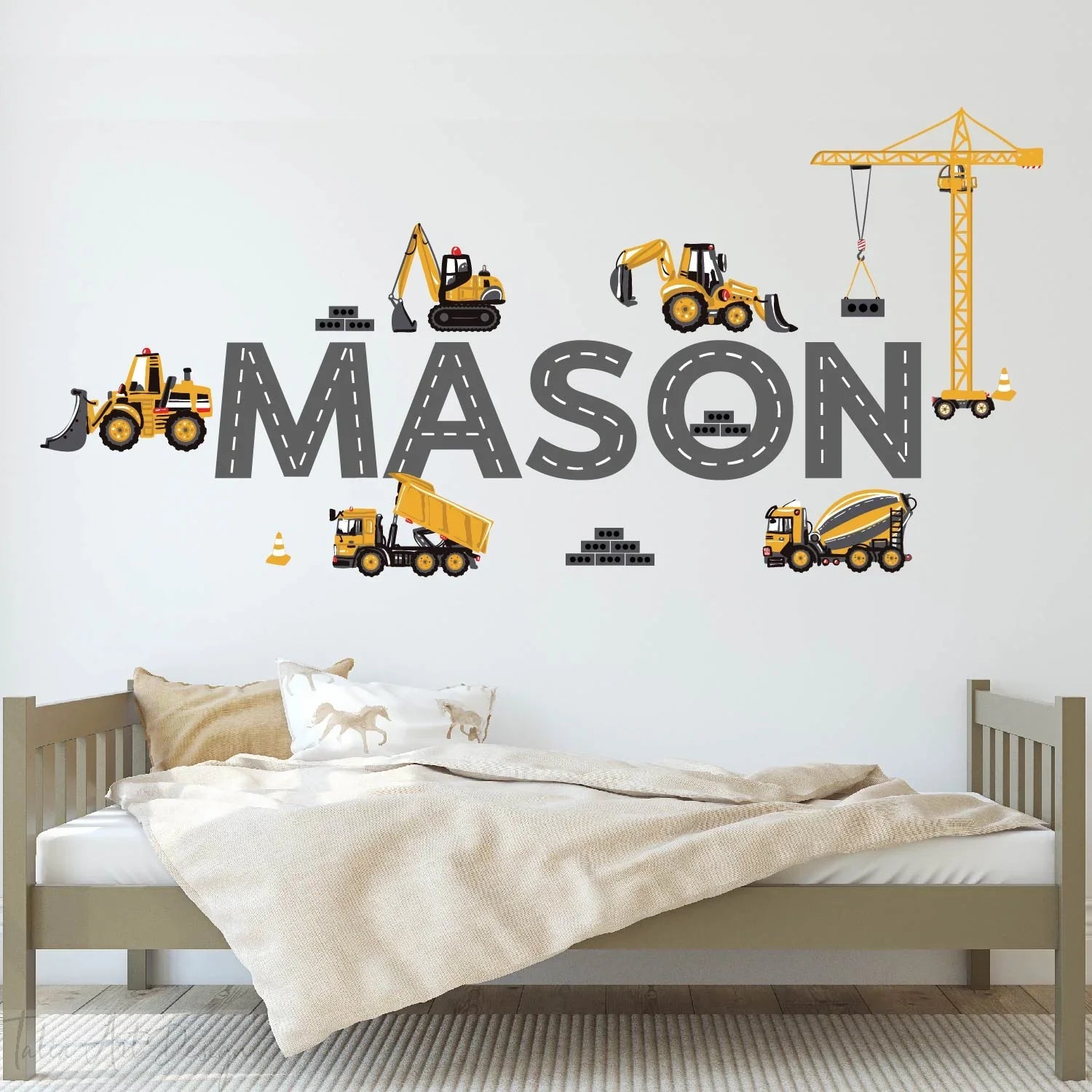 Personalized kids room wall decal with construction vehicles and the name Mason above a bed