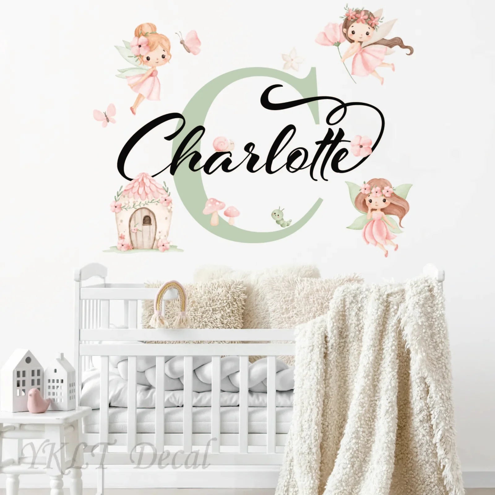 Personalized Charlotte fairy wall decal with pastel fairies, cottage, and butterflies above crib
